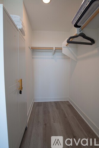 A hallway with a light on and a coat hanger.