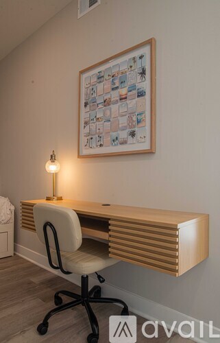 A desk with a chair and a picture on the wall.