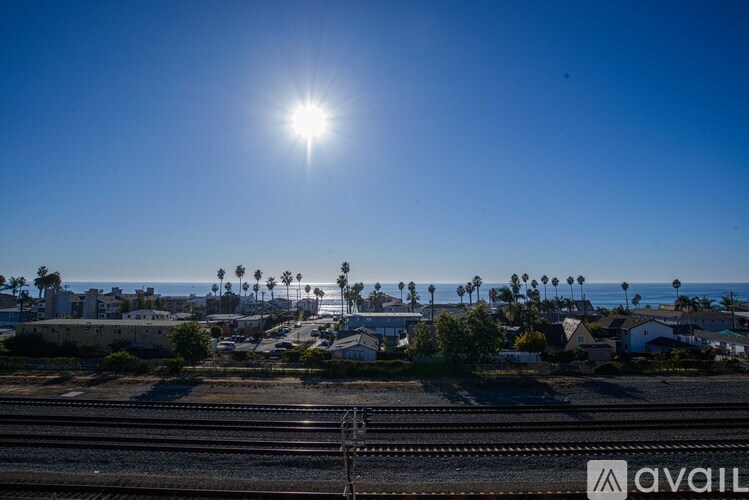 A sunny day with a clear blue sky and a railway track in the foreground.