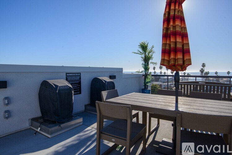 A patio with a table, chairs and an umbrella.