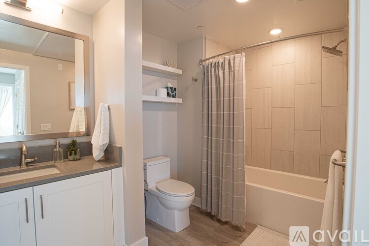 A bathroom with a toilet, sink, and shower.