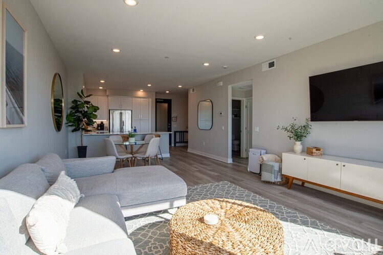 A living room with a white couch and a woven basket on the floor.