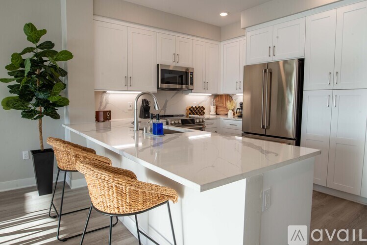 A kitchen with white cabinets and a white countertop.