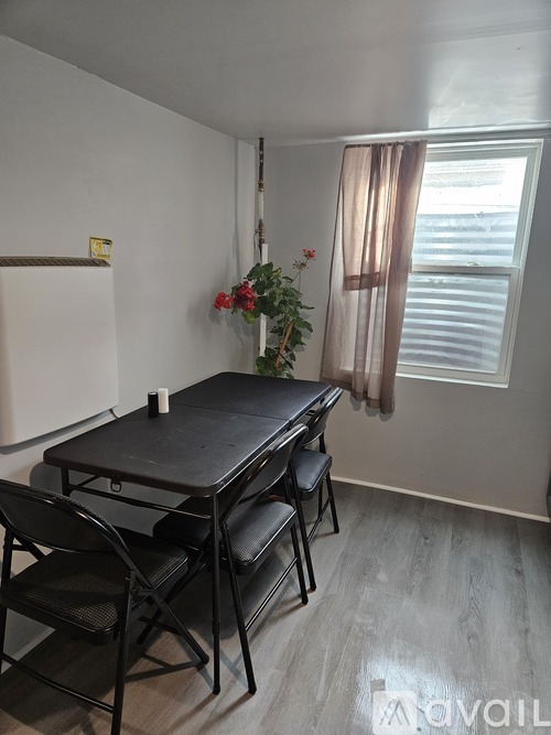 A dining room with a table and chairs.
