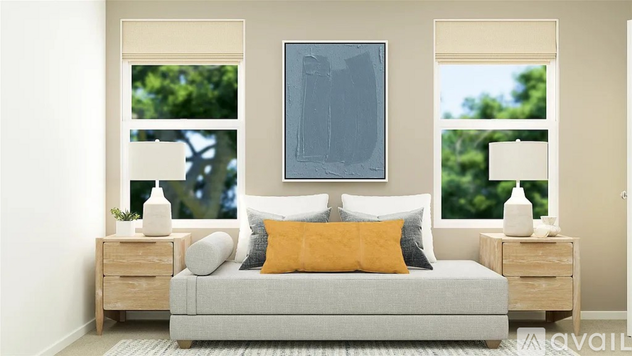 A bedroom with a grey bed, a yellow pillow, and a grey painting on the wall.
