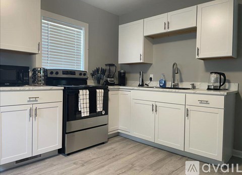 A kitchen with white cabinets and a black oven.