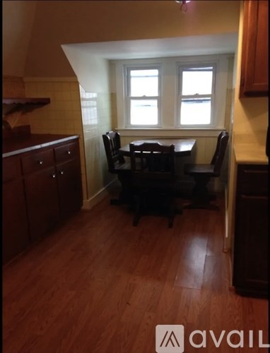 A kitchen with a table and chairs in front of a window.
