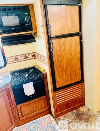 A kitchen with a black stove top oven and a black microwave above a black dishwasher.