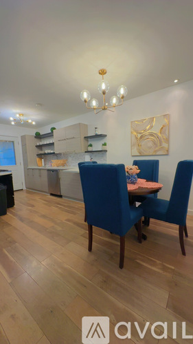 A modern kitchen with a white countertop and wooden flooring.