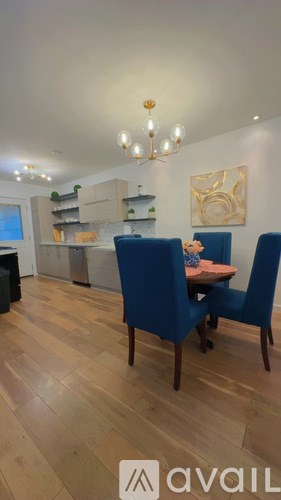 A modern kitchen with a white countertop and wooden flooring.