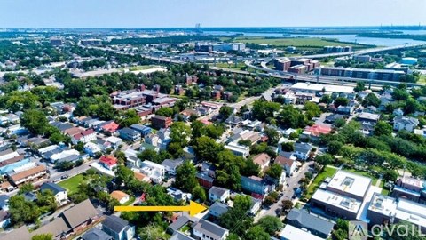 An aerial view of a city with buildings and a river in the distance.