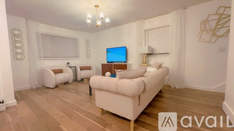 A living room with a white couch and a television on a wooden stand.