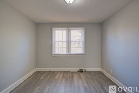 A room with a window and wooden flooring.