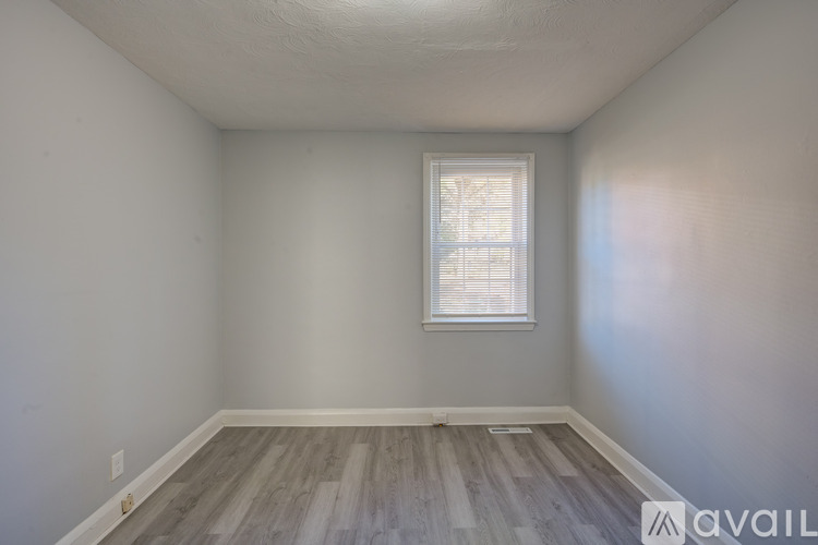A room with a window and wooden flooring.