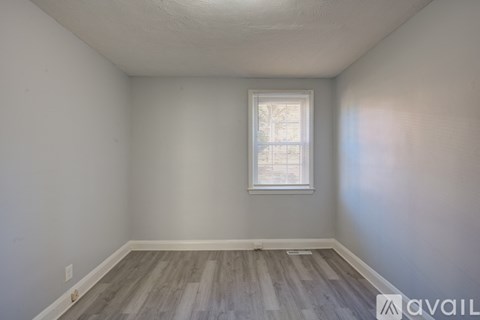 A room with a window and wooden flooring.