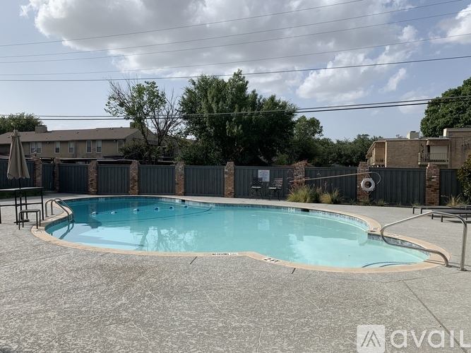 A small pool surrounded by a fence and a patio area.