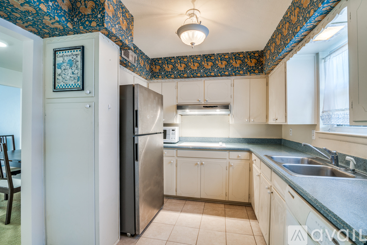 A kitchen with a patterned ceiling and a fridge.