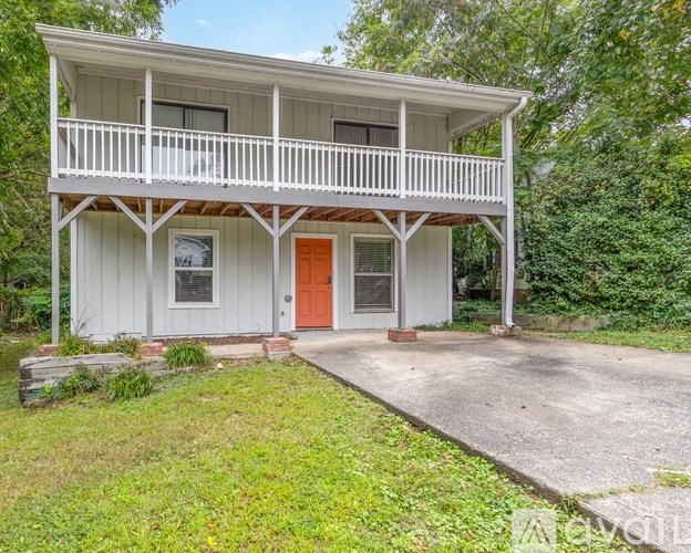 A kitchen with a white stove top oven and a white microwave above it.