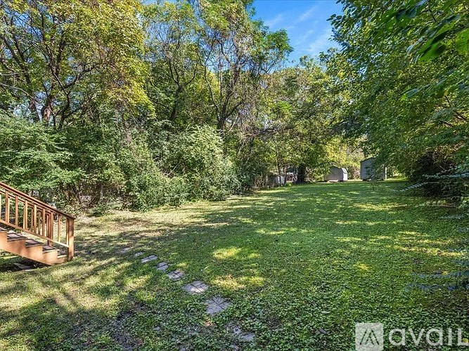 A backyard with a wooden deck and a grassy area.