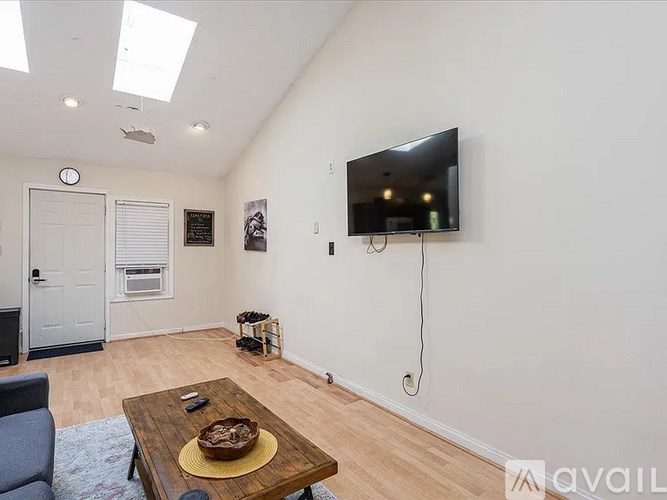 A living room with a flat screen TV mounted on the wall.