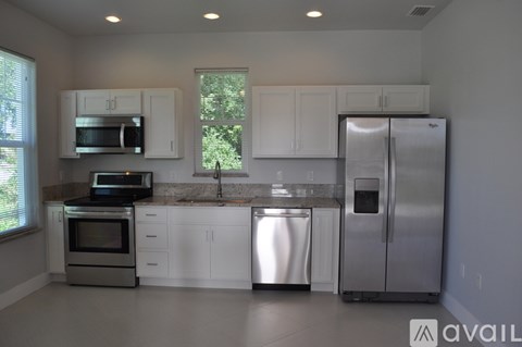 A kitchen with white cabinets and stainless steel appliances.