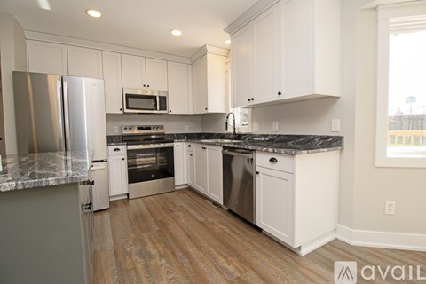 A kitchen with white cabinets and a granite countertop.