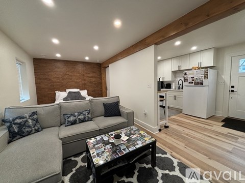 A living room with a grey couch and a coffee table with a patterned top.