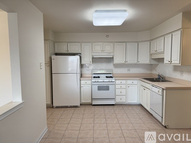 A kitchen with white appliances and cabinets.