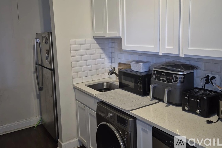 A kitchen with white cabinets and a black stove top.