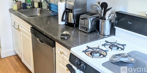 A kitchen with white cabinets and a black stove top.