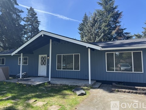 A blue house with a white door and windows is for sale.