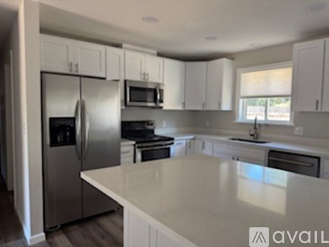 A kitchen with white cabinets and appliances.