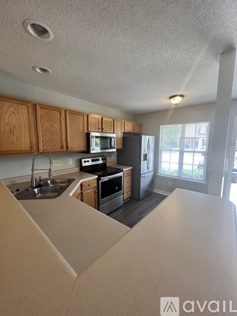 A kitchen with wooden cabinets and stainless steel appliances.