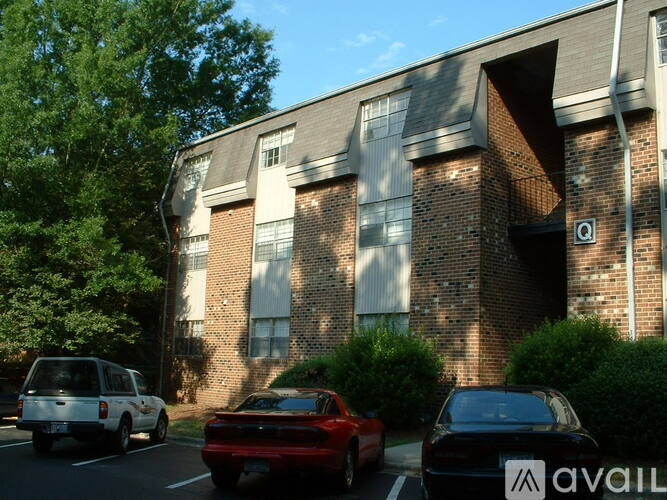 A black car with the word "AVAILABLE" on the side is parked in front of a brick building.