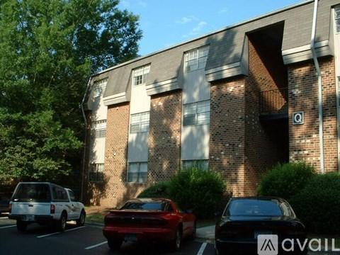 A black car with the word "AVAILABLE" on the side is parked in front of a brick building.