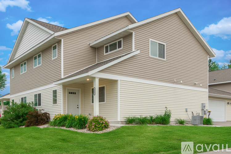 A house with a beige siding and a white door is for sale.