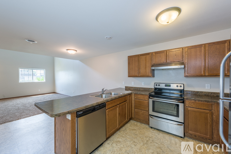 A kitchen with wooden cabinets and stainless steel appliances is available for rent.