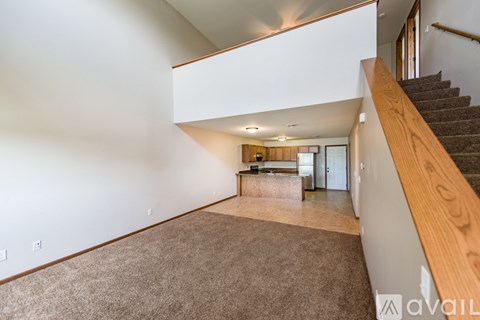 A spacious living room with a staircase on the right side.