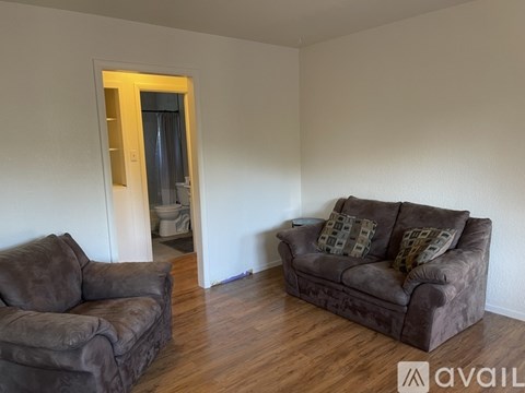 A living room with a brown couch and a brown chair.