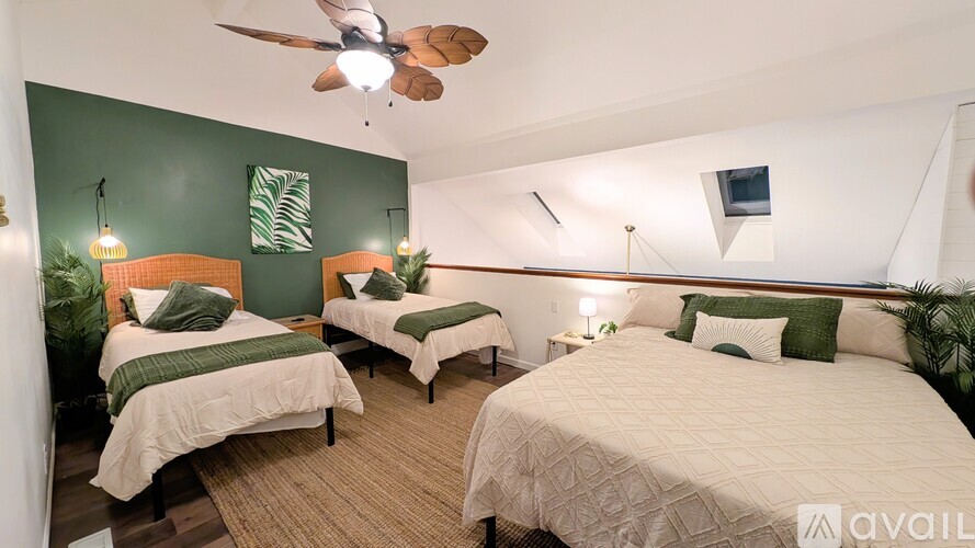 A room with two beds and a ceiling fan.