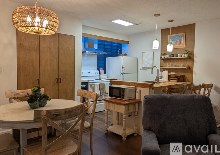 A kitchen with a table and chairs in the foreground and a refrigerator in the background.