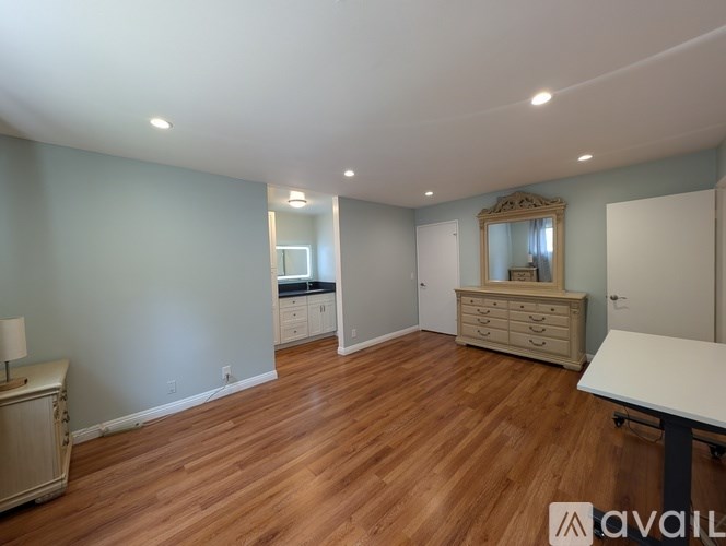 A room with wooden floors and a large mirror on the wall.