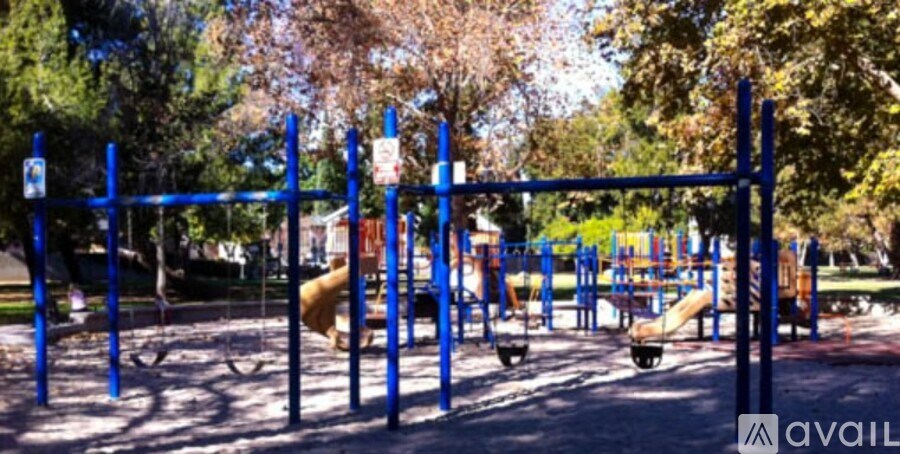 A playground with a blue swing set and a yellow slide.