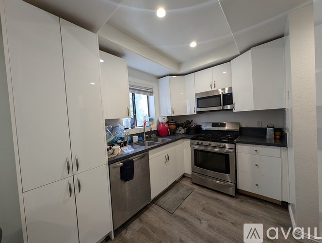 A kitchen with white cabinets and stainless steel appliances.