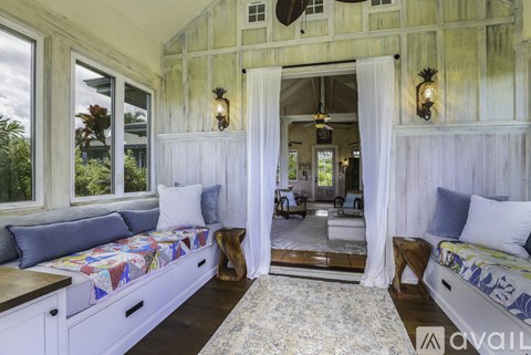 A room with a white wooden wall and a window seat.