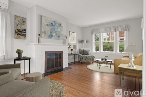 A living room with a fireplace and a painting on the wall.
