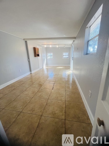 A long hallway with tiled floors and white walls.