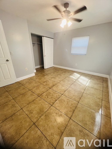 A room with a ceiling fan and tile flooring.