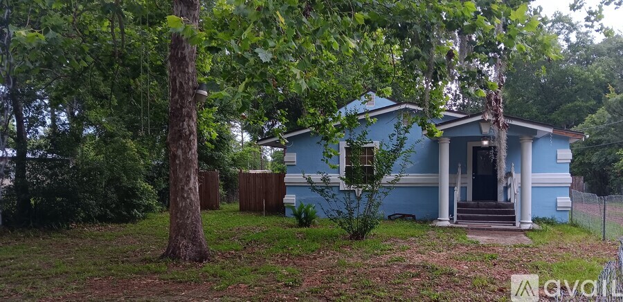 A blue house with a white door and steps leading up to it.