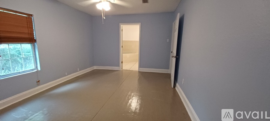 A room with a window and a door is available for rent.